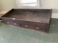 Full view of wooden captain's bed showing drawers and overall condition