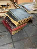 Stack of four small antique military manuals showing size and wear