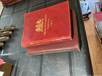 Front covers of two small red military training books stacked