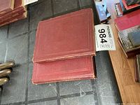 Stack of two red cloth military manuals on tabletop