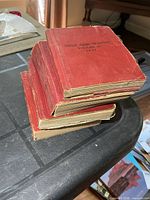 Stack of four red Small Arms Training manuals showing aged condition