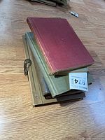 Stack showing four military books with varied bindings and colours