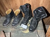 Two pairs black combat boots on surface
