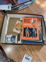 Overview of tray showing books, pamphlets, photo frame, ephemera