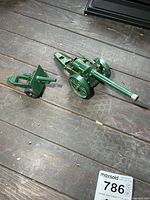 Both Britains green die-cast cannons side-by-side on wood surface
