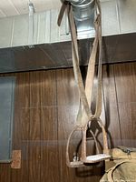 Pair of stirrups hanging from duct with leather straps visible