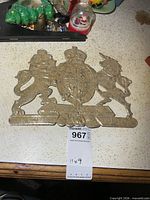 full view of cardboard coat of arms plaque with measuring tag