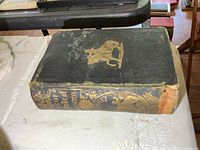 Front cover showing gilt horse-and-rider design, wear on edges