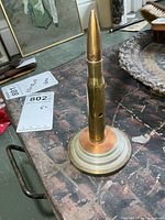 Full view of brass shell mounted on base