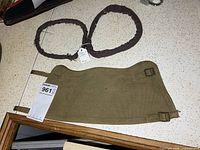 canvas gaiter and two brown trouser weights on countertop