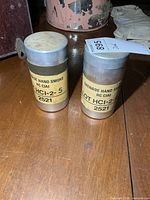 Both aluminum smoke grenade cans side by side