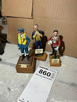 Front view of all three lead soldier figurines with identification plates