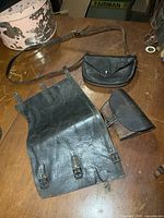 Overview of three leather items: gaiter, satchel, pouch