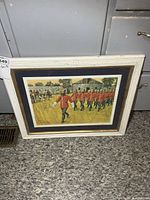 Framed print leaning against cabinet, showing full frame and mat