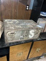 Front view showing box, clasp, handles, stenciled markings