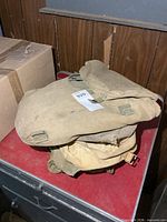 Stack of khaki canvas bags on red surface