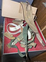Multiple belts and accessories on red surface