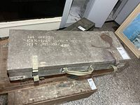Top view of olive drab military box with canvas straps