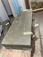 Top view of olive drab steel military box with canvas handles