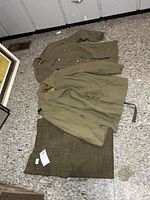 Overall view of two jackets and trousers laid out