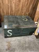Front and side view of painted wooden crate with lettering and latch