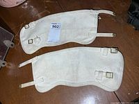 Both canvas gaiters laid flat showing overall condition and hardware