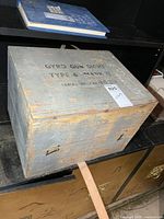 Closed painted wood case front view with text