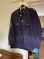 Full view of jacket hanging, showing pockets, buttons, epaulettes