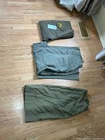 All three garments laid out: folded wool trousers, unfolded cotton trousers, skirt