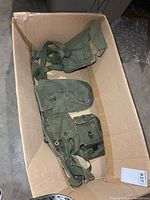 Box containing three green canvas military pouches