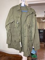 Full front view of olive field jacket on hanger