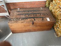 Top view of closed wooden trunk showing stencil and latch