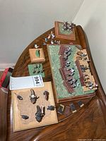Overview of all five diorama setups, extra figures and fence pieces on a tabletop