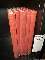 Set of five red hardcover books standing vertically