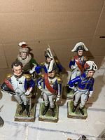 Six porcelain Napoleonic soldier figurines standing in two rows