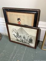 Both framed images leaning against wall