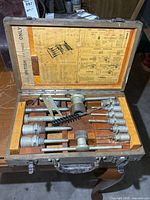 open wooden case with tools and instructions visible