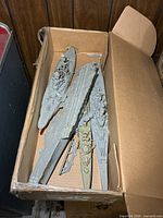 Box showing four assembled warship models with loose parts