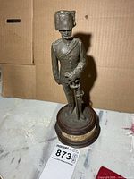 Full view of statue on base with reference tag visible