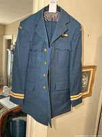 Front view of blue military jacket on hanger