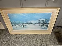 Full view of framed print leaning against wall