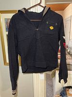 Front view of naval wool jumper hanging, showing collar and overall form