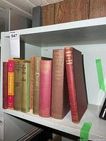 All seven books upright on shelf showing spines