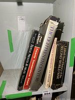 Six hardcover books on shelf showing visible spines