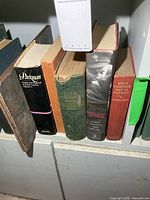 Five vintage hardcover books lined on shelf