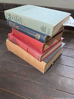 Stack of five hardcover military books showing varied spine colors and wear