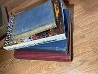 Stack of five war books showing dust-jacketed Wellington’s War and various cloth-bound volumes