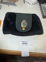 Top view of hat showing black faux fur body and green wool flap