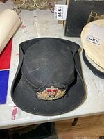 Front view of black felt WRNS hat on table showing badge