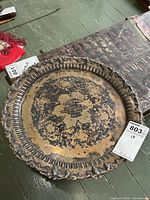 Full view of tarnished 15" round silver-plated tray with ornate rim and inscription
